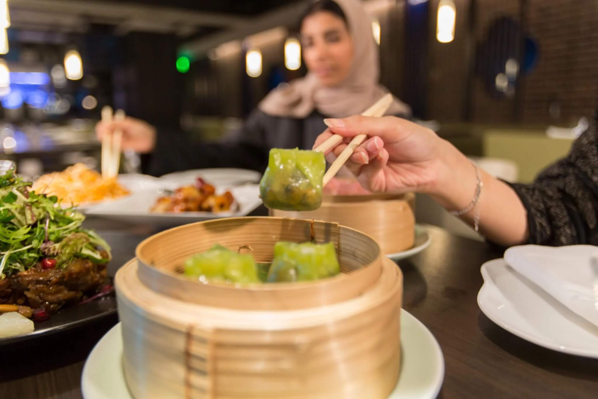 Woman eating dim sum at Yauatcha Riyadh